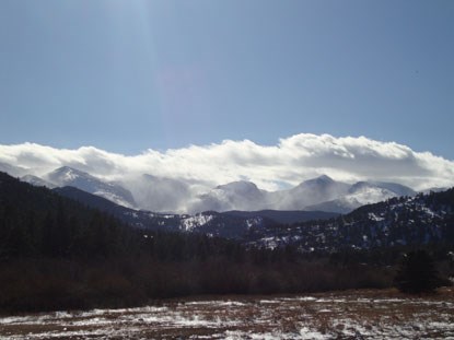 On windy winter days the peaks of the Rockies fog over with snow.