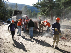Photo park volunteers feed beetle-killed trees into the chipper.