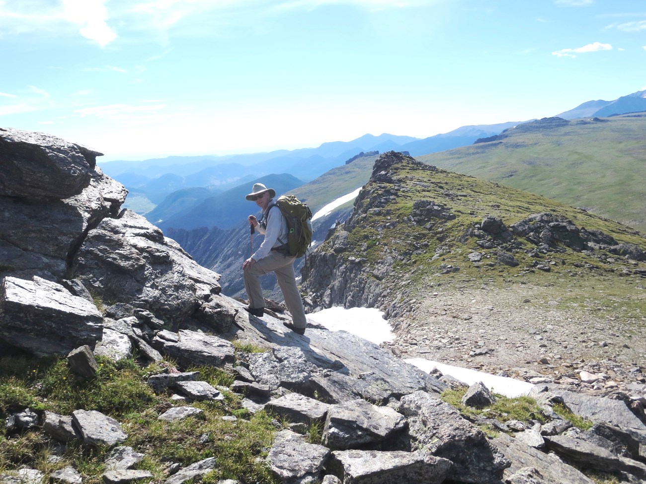 A hiking is climbing on a mountain trail