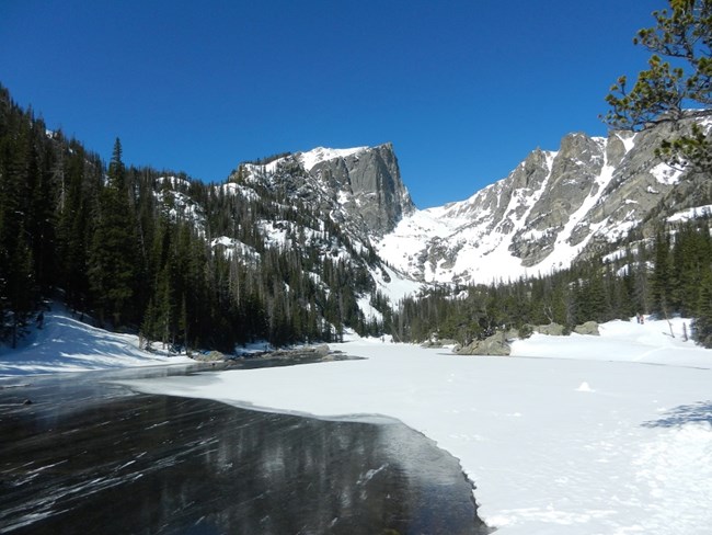 Dream Lake in spring, partly covered with snow and icy. Taken May 2, 2025