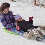 Mom and child sledding at Hidden Valley