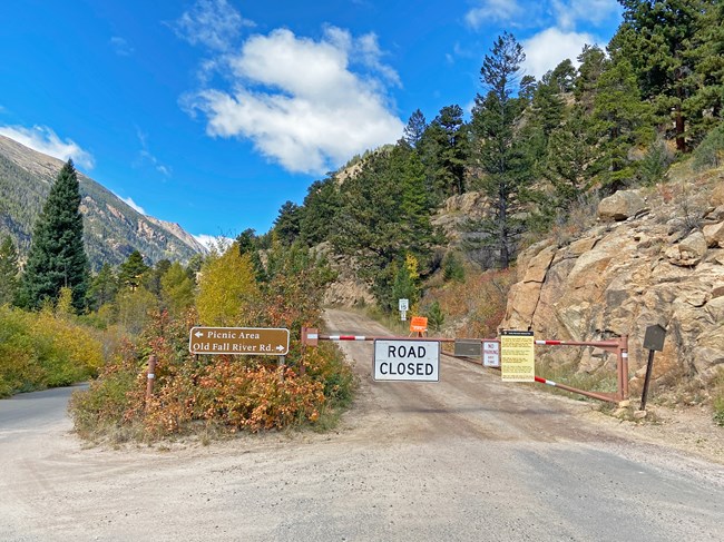 The road closed gate is locked and a sign is posted at the entrance to Old Fall River Road showing the road is closed for the winter season.