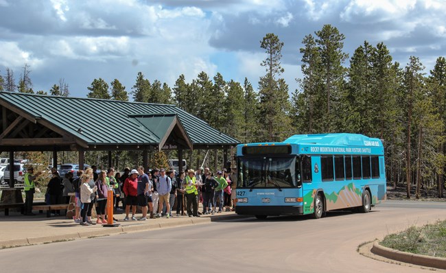Park visitors are in line to board RMNP's free shuttle bus at Park & Ride