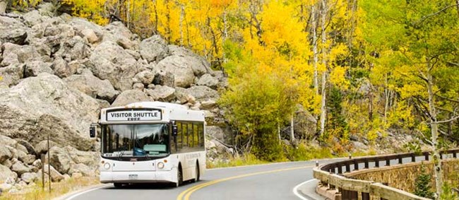 Shuttle bus driving on Bear Lake Road in fall Shuttle bus driving on Bear Lake Road in fall