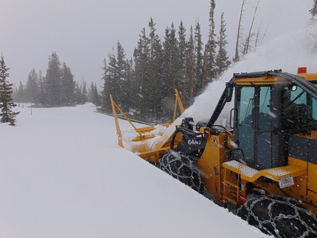 A rotary snowplow is plowing deep snow on Trail Ridge Road on May 21 2024