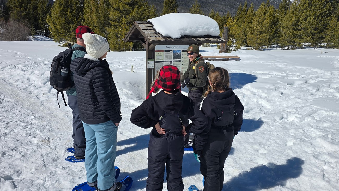 A group of visitors are on a ranger-led snowshoe hike in the Kawuneeche Valley