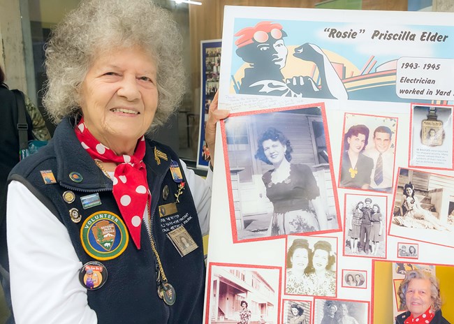 Senior caucasian female smiles at the camera while holding a board with a photo of her younger self.