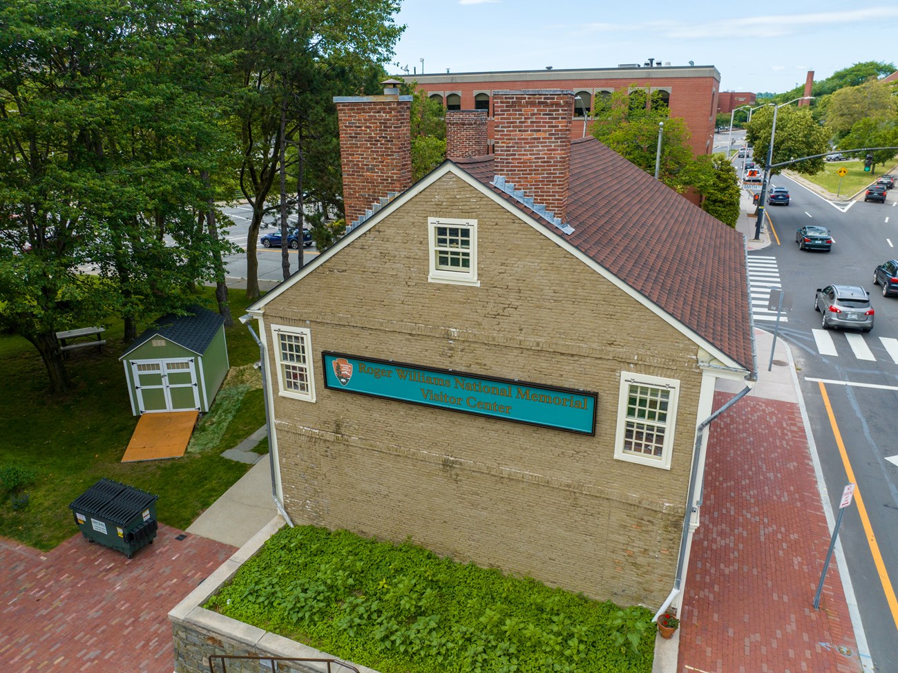 An old house with wood shingle roof, chimney, and green walls