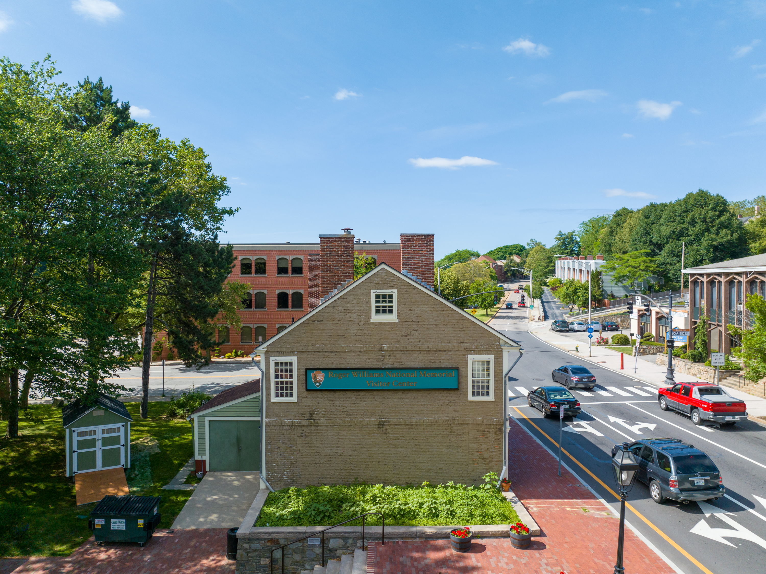 A colonial building, brown brick, with National Park Service sign
