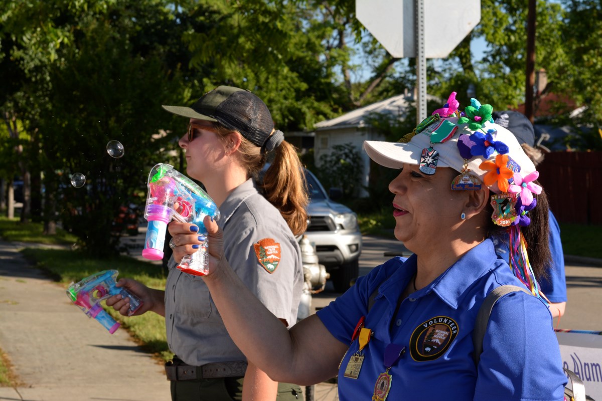 Volunteer holds a bubble gun while marching in the King William Parade