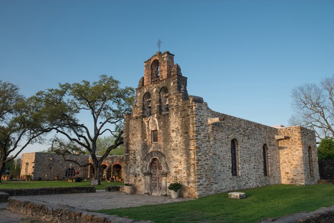 Mission Espada church front, limestone building on sunny day