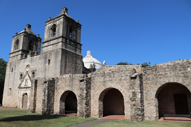 Mission Concepcion with convento arches in foreground and church in background