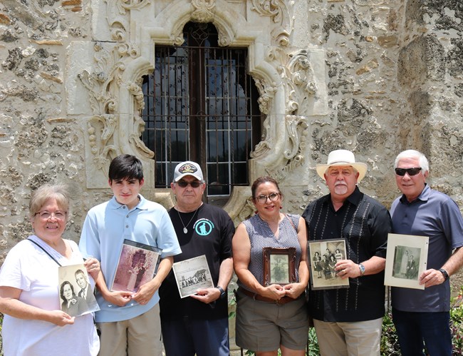 Family holding framed pictures