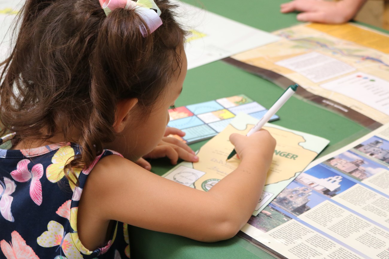 Photo of child filling out the Junior Ranger booklet from above