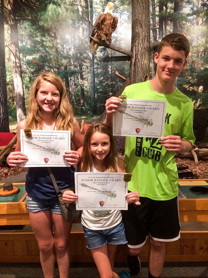 Three new Jr Rangers hold their certificates and badges. Three new Jr Rangers hold their certificates and badges.