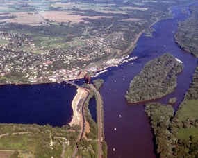 Wide blue river enters from left narrowed at joining point, river going from close to far on right is browner.