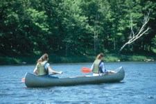 two female canoeists paddle on the river