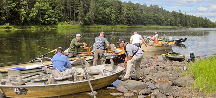 People in boats prepare to get on a river. People in boats prepare to get on a river.