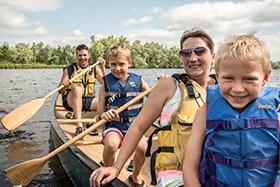 A family paddles a canoe.