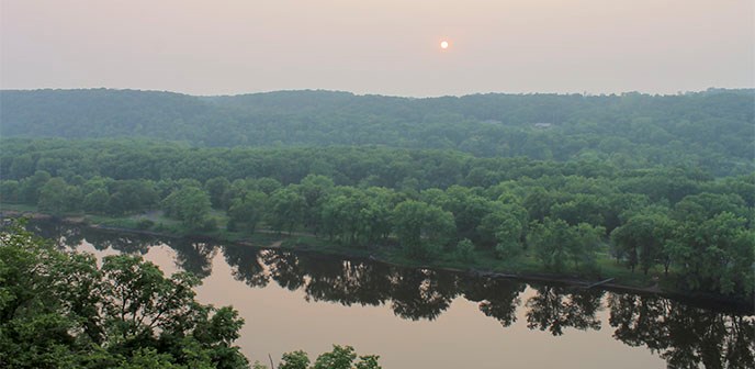 The sun sets over a river.