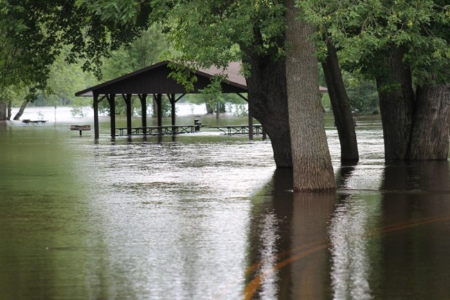 The St. Croix River flows over the road and through a picnic shelter at Osceola Landing on Saturday, June 23, 2012. NPS photo.