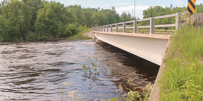 A river flows close to the bottom of a bridge
