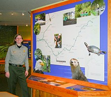 A ranger stands next to a map display.