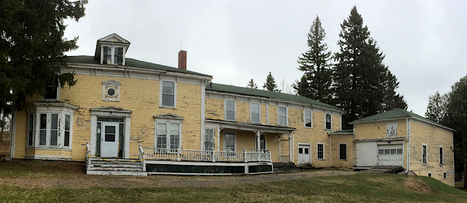 Historic two-story house with peeling yellow paint