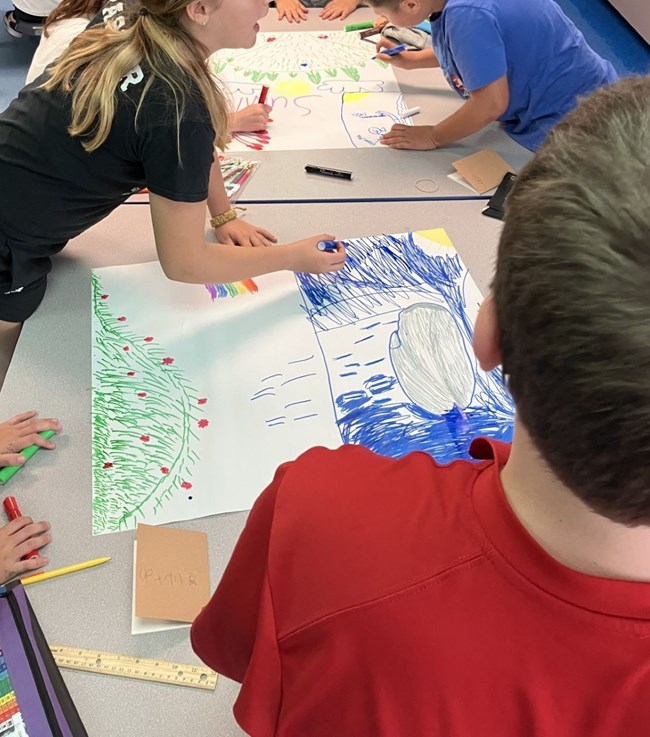 students using markers to create posters