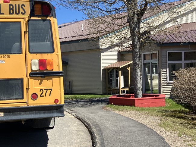 back of a school bus parked in front of a school