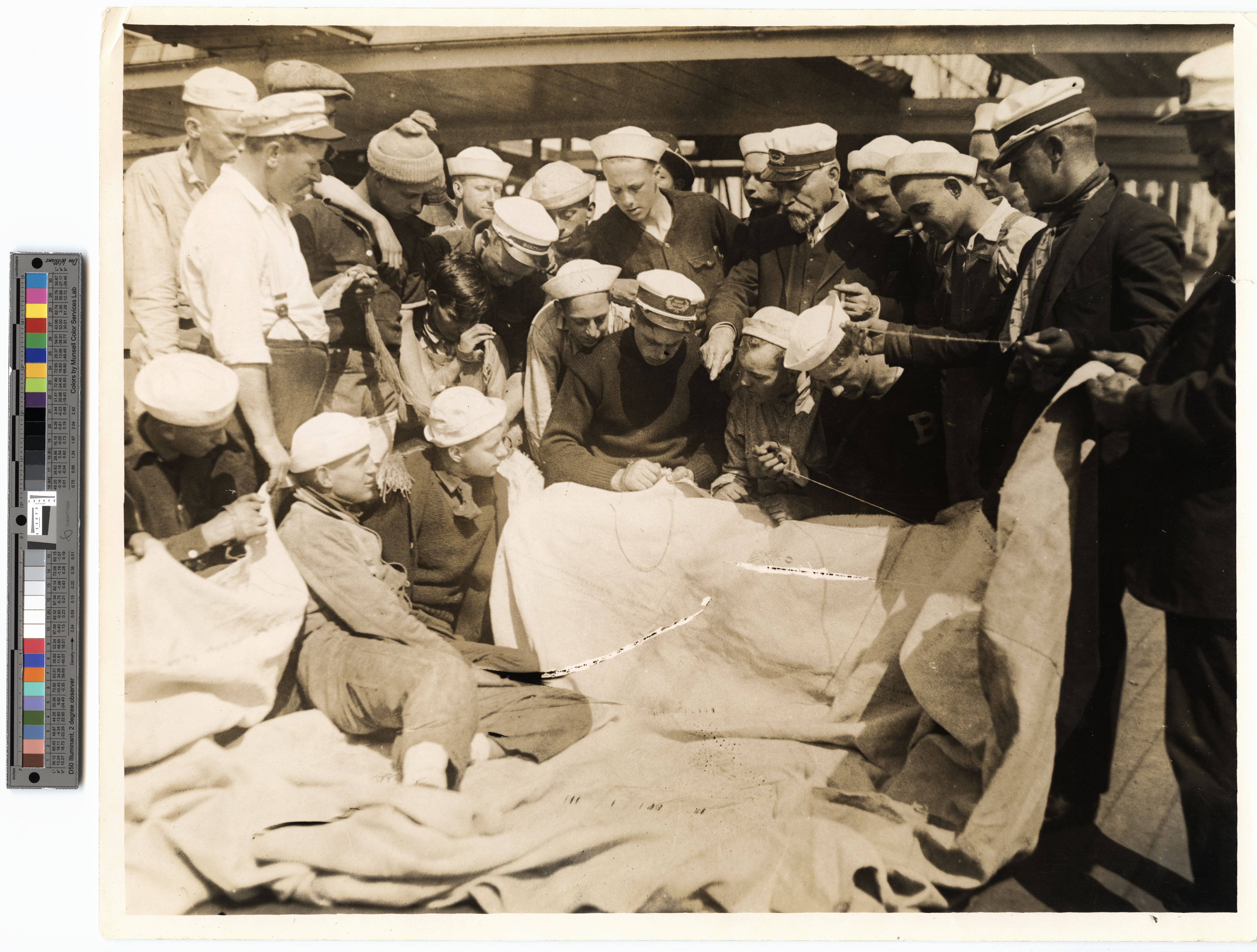 Monongahela (built 1892; bark, 4m: training ship) view on board showing apprentices watching demonstration of sail mending, undated