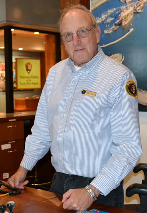 A man standing behind an information desk. A man standing behind an information desk.