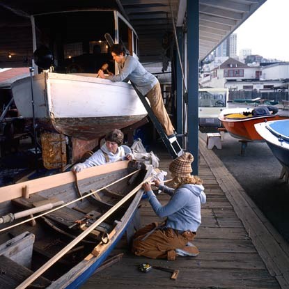 Park volunteers working on two small wooden boats on Hyde Street Pier.