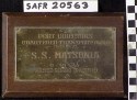 Rectangular panel of brown-stained wood mounting a brass plaque with inscription: "PORT DIRECTOR'S / CHARTERED TRANSPORT AWARD / 12TH N.D. [i.e. Naval District] / S.S. MATSONIA / 8 - 16 -'44 / ARMED GUARD (PACIFIC)."