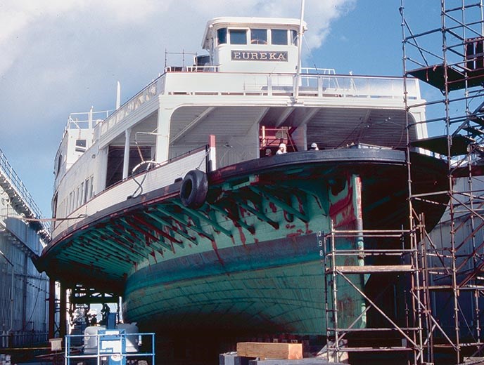A large, wooden ferryboat out of the water.