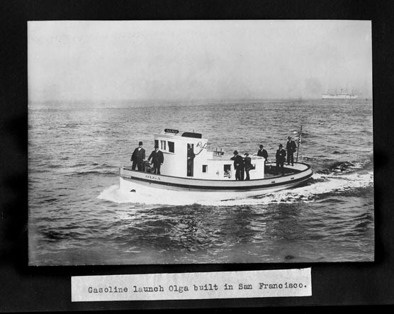 A motor boat on the water with seven men in dark suits riding on the deck.