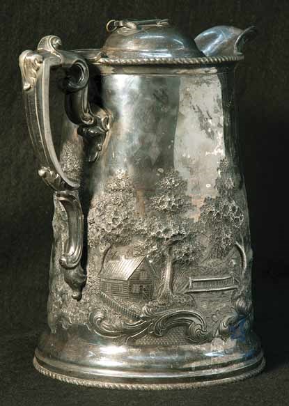 A side view of a silver pitcher.