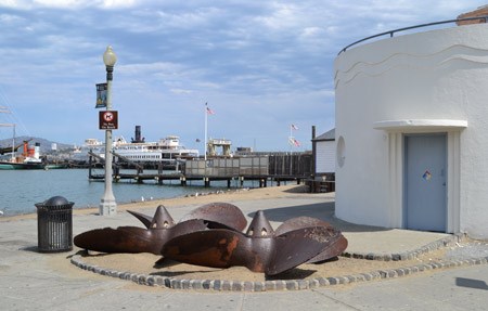 Two large ship propellers laying on their sides on the ground.