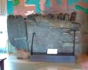 Color photograph of the stern section of the Niantic in the museum on display in front of the Hiler murals