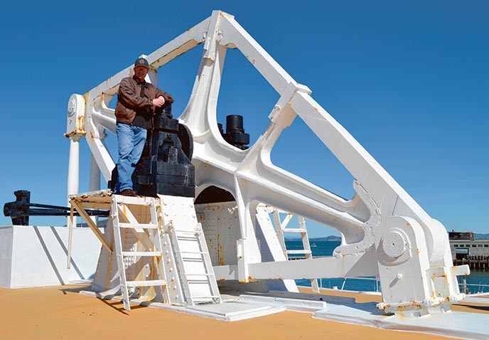 A man standing next to a large beam.