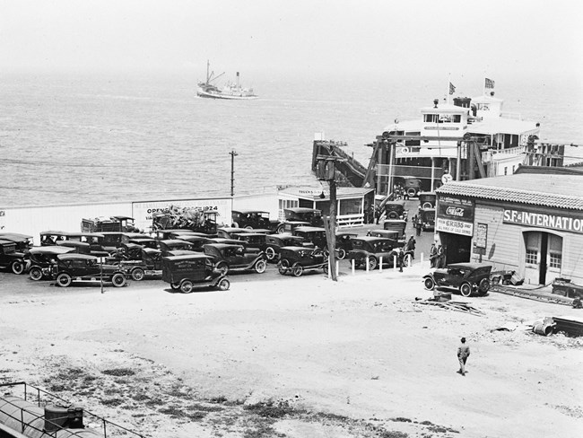 historical photo of automobiles lining up to drive onto the ferry at Hyde Street Pier