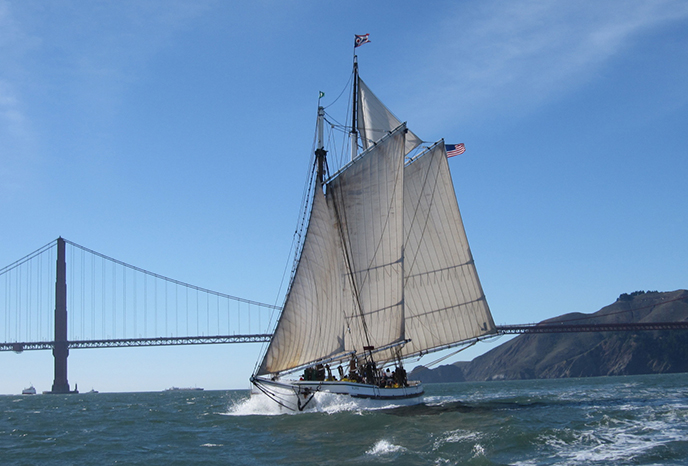1891 scow schooner Alma underway on San Francisco Bay 1891 flat-bottomed schooner on San Francisco Bay with her sails raised and the Golden Gate Bridge in the background