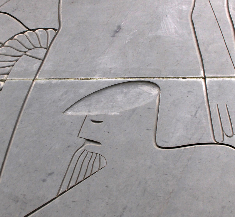 Image of a man carved on gray green slate.