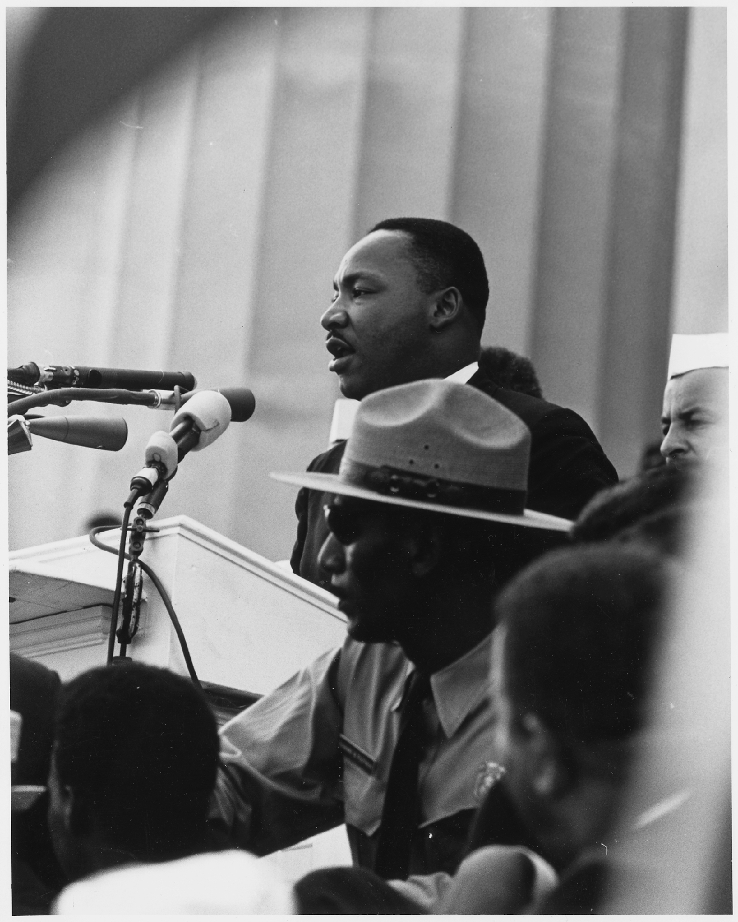 Dr. Martin Luther King, Jr. delivers his "I Have A Dream" speech from a podium with a National Park Service ranger in the foreground