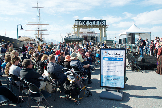 A group of people sitting on chairs on Hyde Street Pier.