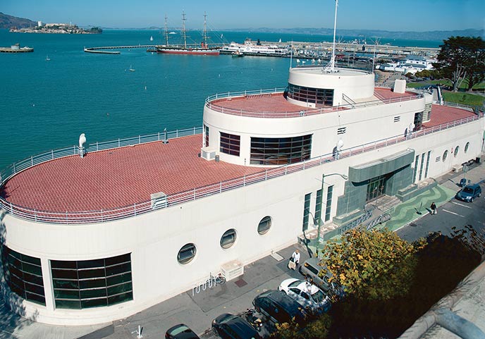 A large white building with a red tile roof.