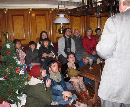 A group of people sitting close together and listening to a story.