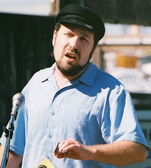 A man in a captain's cap singing.