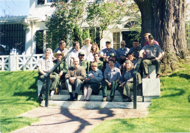 group of park rangers in front of historic house