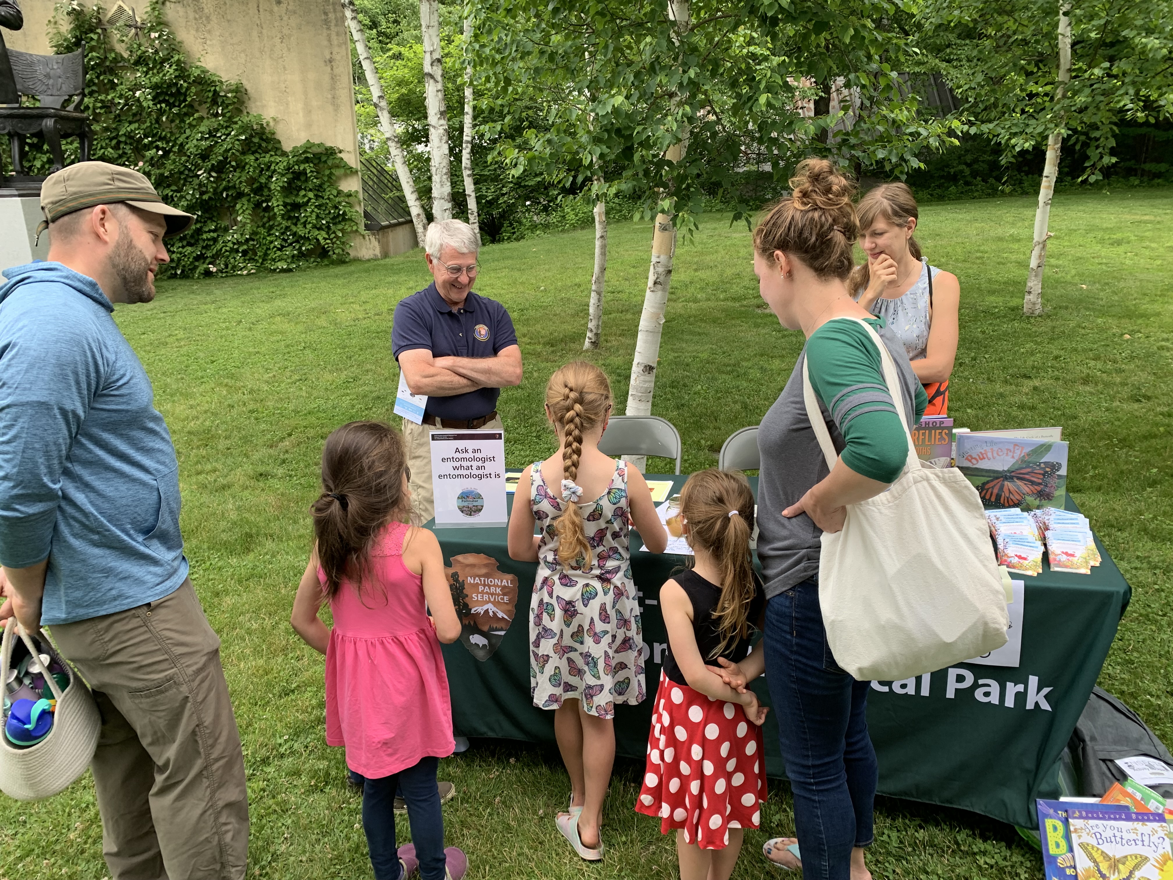 family speaking with scientists at table